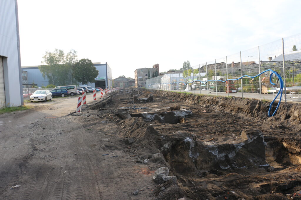 Budowa drogi przez Dozamet - dalsza część budowanej drogi w tle market mrówka