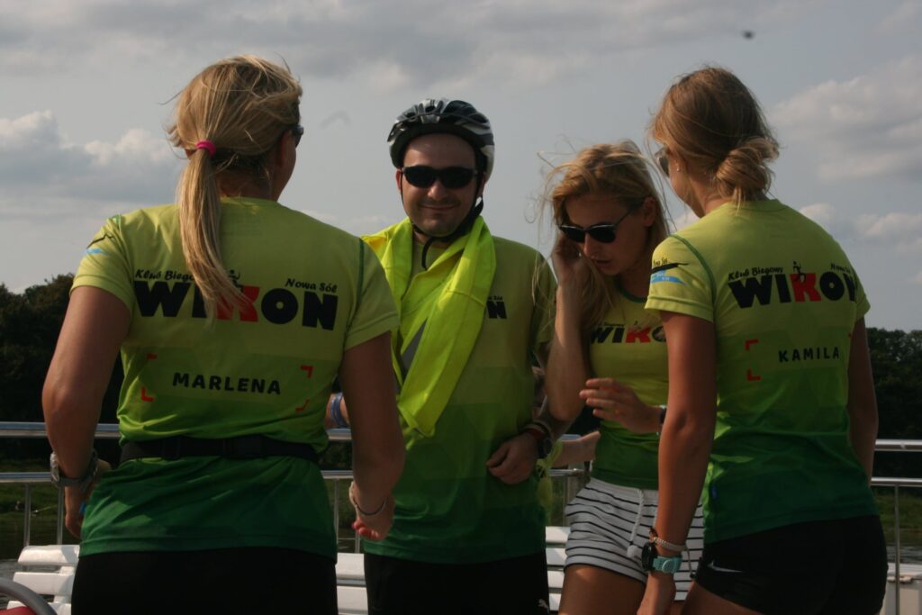Na zdjęciu znajdują się uczestnicy rejsu laguną po Odrze: trzy kobiety i jeden mężczyzna. Mężczyzna jest w kasku rowerowym.